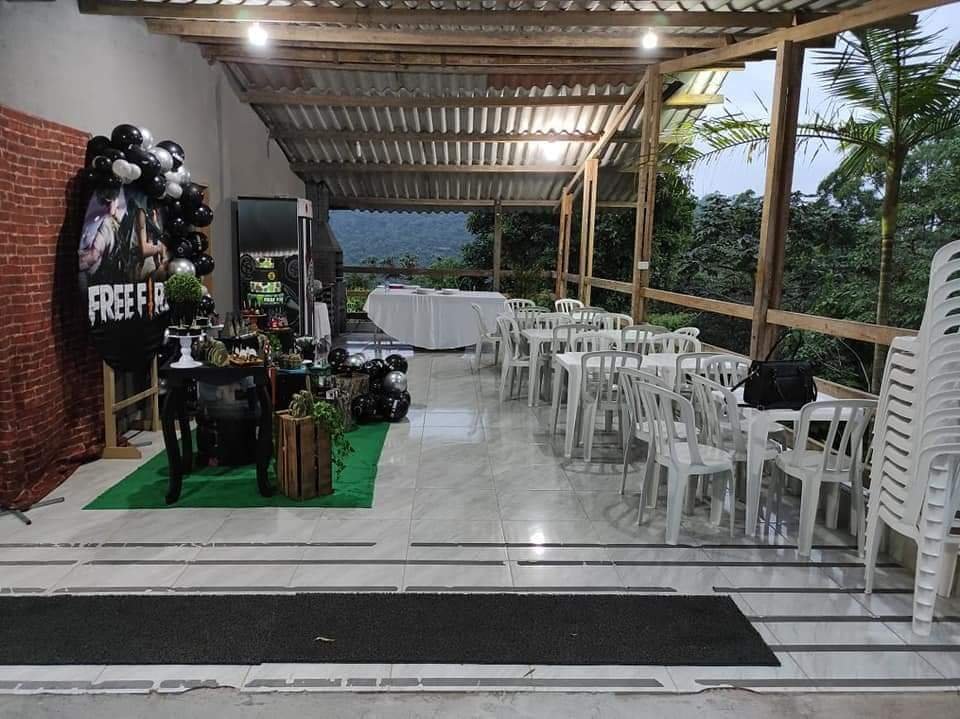 Salão com decoração de festa e vista para a mata