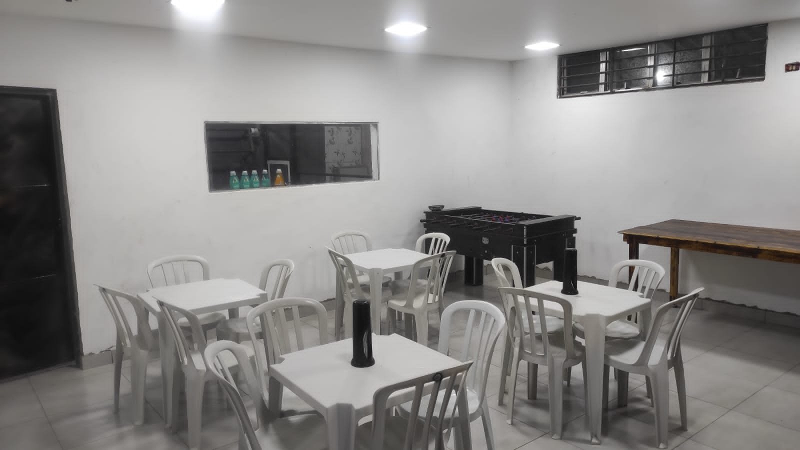 Salão com mesas e pebolim
