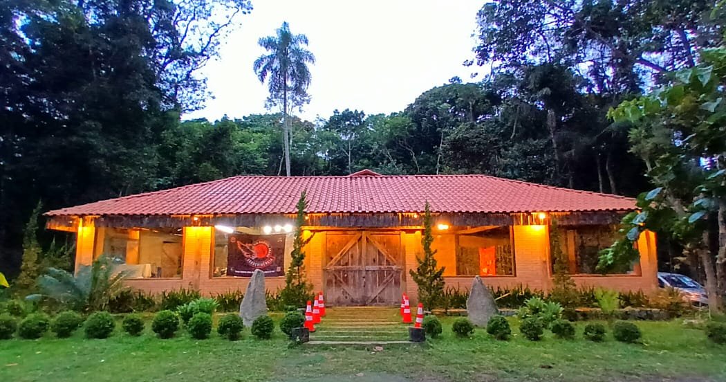 Salão iluminado no fim de tarde, com jardim na frente